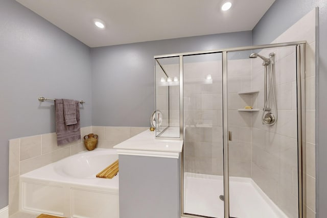 bathroom with recessed lighting, a garden tub, and a stall shower