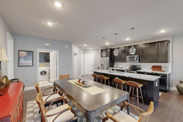 dining area with dark wood-style floors, washer / clothes dryer, and recessed lighting