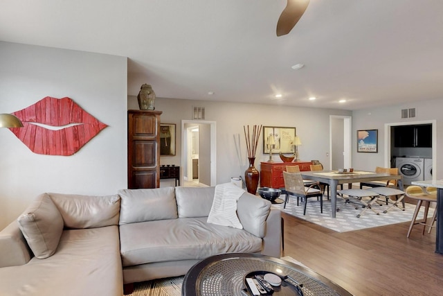 living room with recessed lighting, visible vents, wood finished floors, and washing machine and clothes dryer