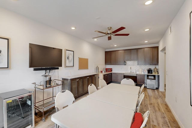 interior space with dark brown cabinets, beverage cooler, and light wood finished floors