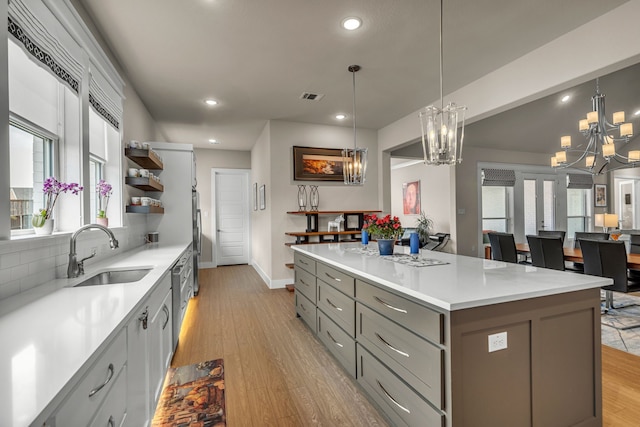 kitchen with visible vents, gray cabinets, light wood-type flooring, open shelves, and a sink