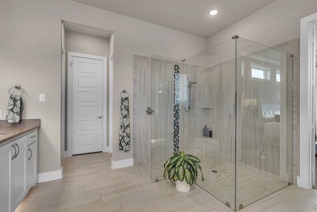 full bath featuring a shower stall, baseboards, and vanity