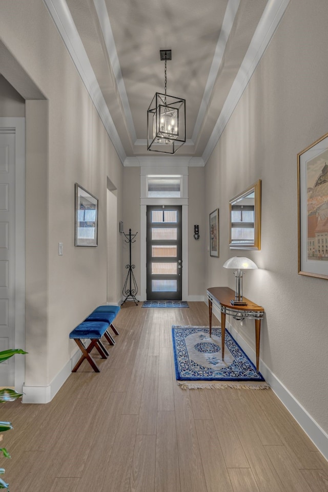 entrance foyer with ornamental molding, wood finished floors, and baseboards