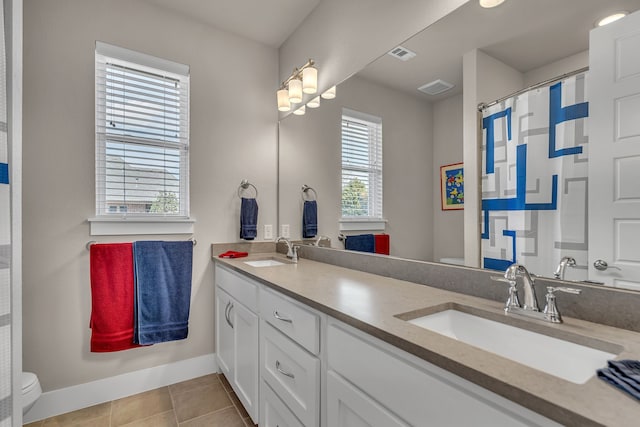 bathroom with toilet, visible vents, a sink, and tile patterned floors