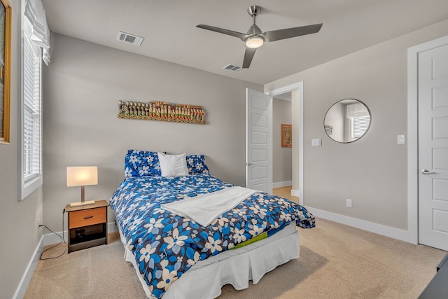 carpeted bedroom featuring a ceiling fan, visible vents, and baseboards