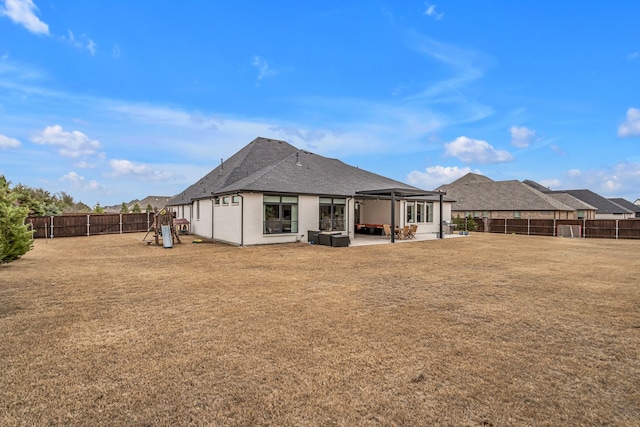 back of property with a patio, a lawn, a playground, and a fenced backyard