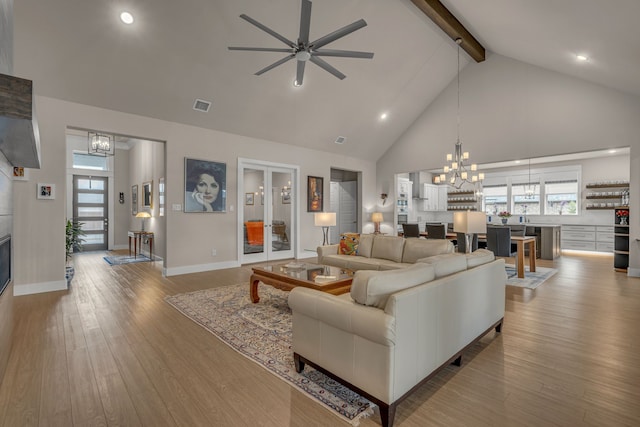 living room with a healthy amount of sunlight, hardwood / wood-style flooring, and beamed ceiling