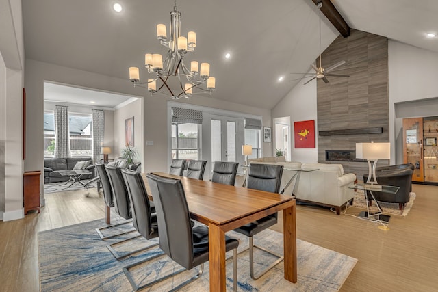 dining space with high vaulted ceiling, recessed lighting, ceiling fan with notable chandelier, light wood finished floors, and beamed ceiling