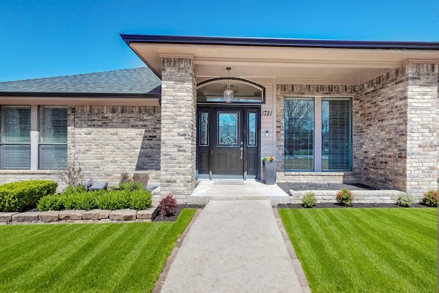 1721 Plummer Dr, Rockwall, TX 75087 - property entrance with a lawn, brick siding, and roof with shingles
