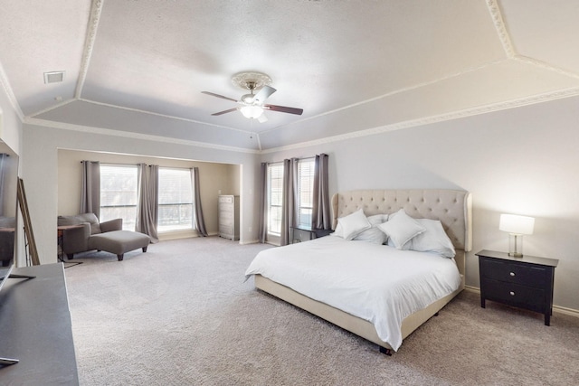 carpeted bedroom with baseboards, visible vents, lofted ceiling, a tray ceiling, and crown molding