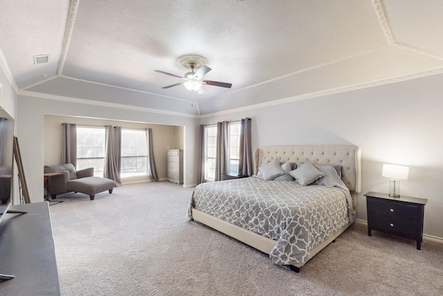 carpeted bedroom featuring visible vents, baseboards, a tray ceiling, lofted ceiling, and ornamental molding