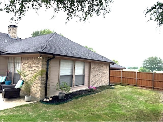 1721 Plummer Dr, Rockwall, TX 75087 - view of side of home featuring brick siding, a chimney, roof with shingles, and a patio area