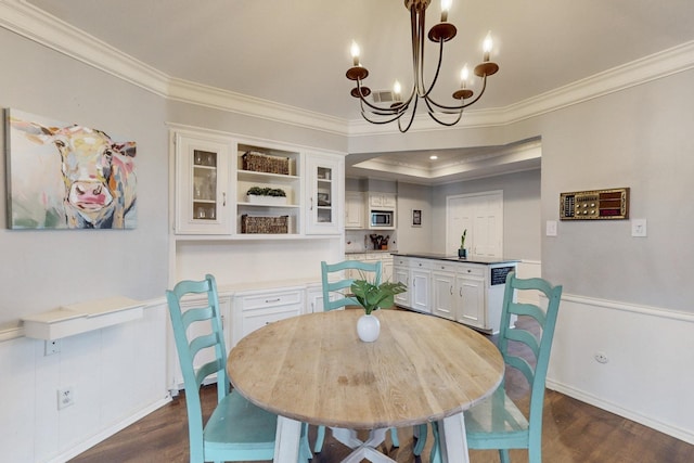 dining room featuring dark wood finished floors, crown molding, and an inviting chandelier