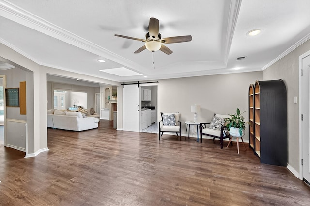 1721 Plummer Dr, Rockwall, TX 75087 - sitting room featuring a barn door, ornamental molding, a raised ceiling, ceiling fan, and dark wood-type flooring