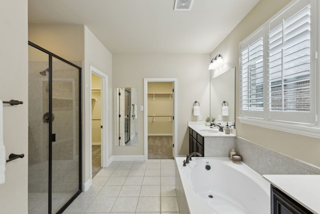 bathroom with tile patterned flooring, vanity, visible vents, a spacious closet, and a shower stall