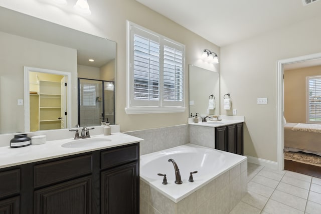 ensuite bathroom featuring a bath, a stall shower, a sink, and tile patterned floors