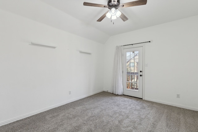 carpeted spare room with vaulted ceiling, a ceiling fan, and baseboards