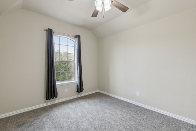 carpeted spare room featuring vaulted ceiling, ceiling fan, and baseboards