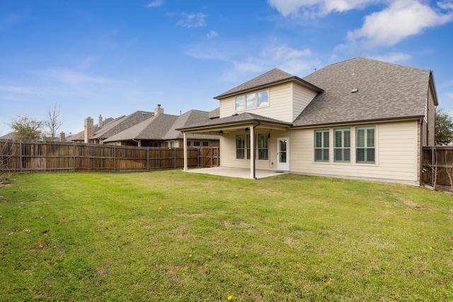 rear view of house with a yard, a fenced backyard, a patio, and roof with shingles