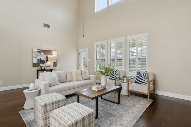 living room with wood finished floors, visible vents, and baseboards