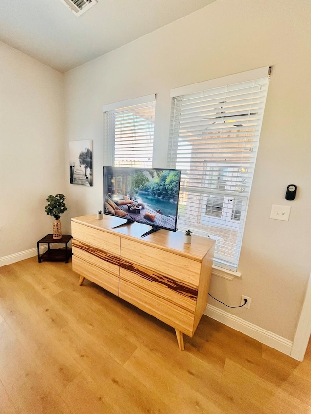 home office with light wood-type flooring, visible vents, and baseboards