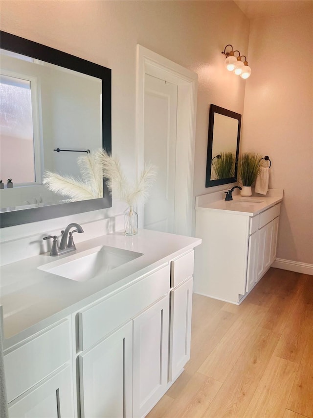 bathroom with baseboards, wood finished floors, and vanity