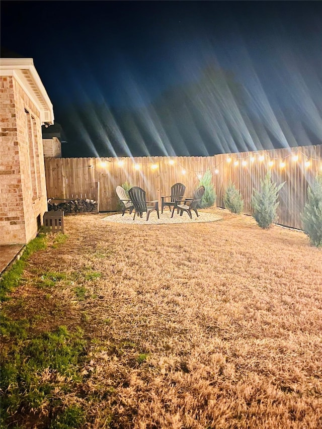 yard at twilight featuring a fenced backyard