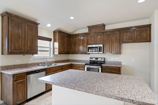 kitchen with light tile patterned floors, a kitchen island, appliances with stainless steel finishes, a sink, and recessed lighting