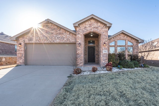 view of front of property featuring driveway, an attached garage, and brick siding