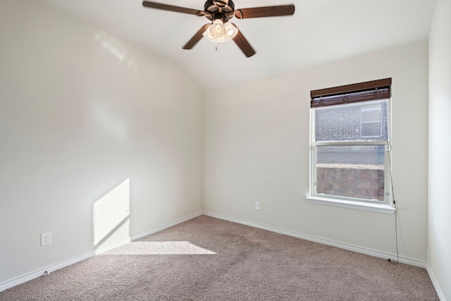 spare room featuring lofted ceiling, carpet, baseboards, and a ceiling fan