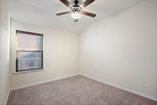 empty room with carpet floors, ceiling fan, baseboards, and vaulted ceiling