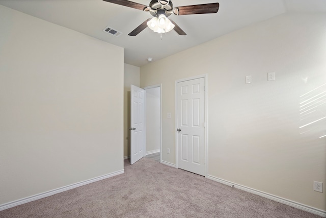 unfurnished bedroom featuring light carpet, a ceiling fan, visible vents, and baseboards