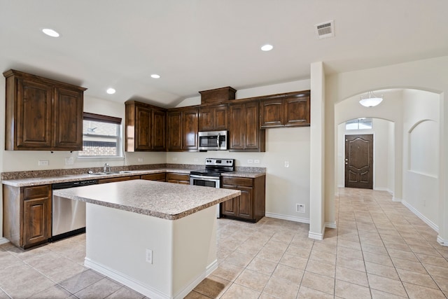 kitchen featuring dark brown cabinetry, visible vents, appliances with stainless steel finishes, light countertops, and a sink