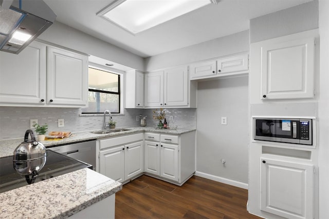 kitchen featuring white cabinets, stainless steel microwave, dark wood-style flooring, ventilation hood, and a sink