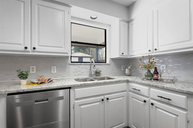 kitchen featuring decorative backsplash, white cabinets, dishwasher, light stone counters, and a sink