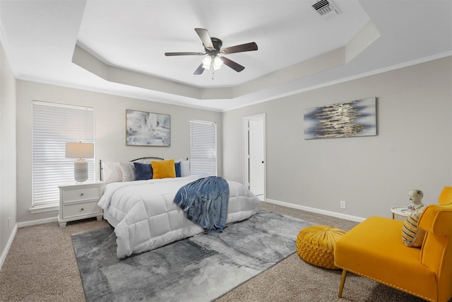 bedroom featuring carpet flooring, a raised ceiling, visible vents, and baseboards