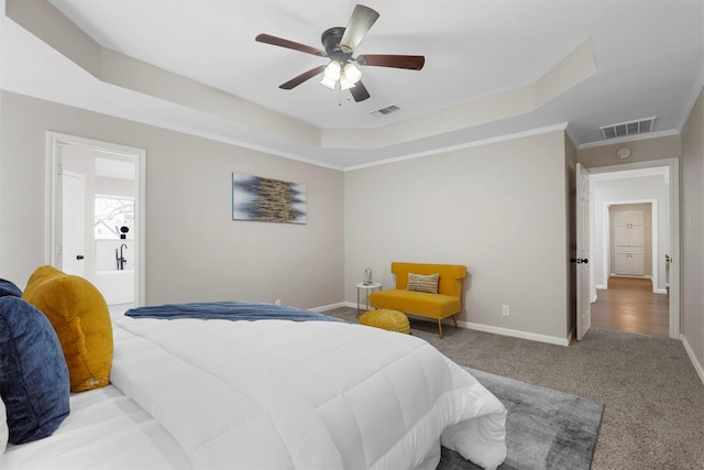 carpeted bedroom featuring a ceiling fan, visible vents, a tray ceiling, and baseboards