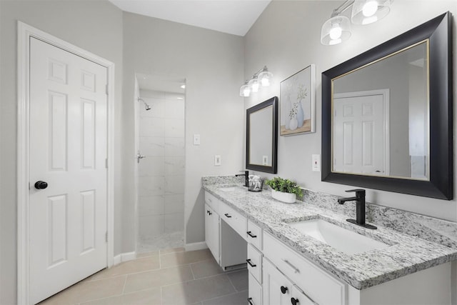 full bath with double vanity, tiled shower, a sink, and tile patterned floors