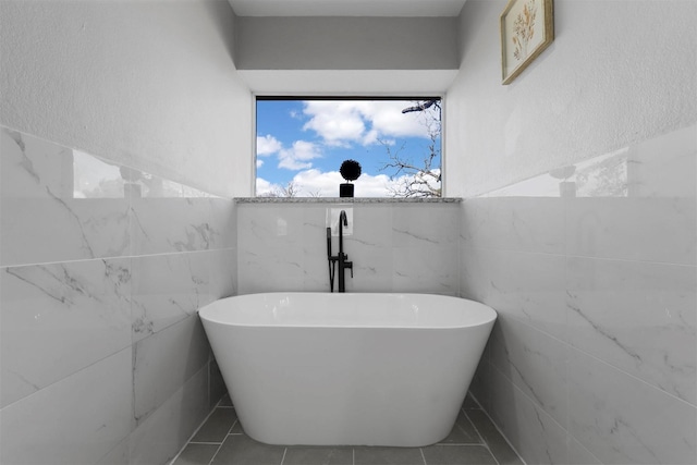 bathroom featuring tile patterned flooring and a freestanding tub