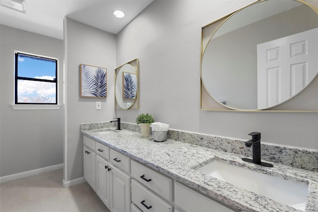 bathroom with visible vents, baseboards, a sink, and tile patterned floors