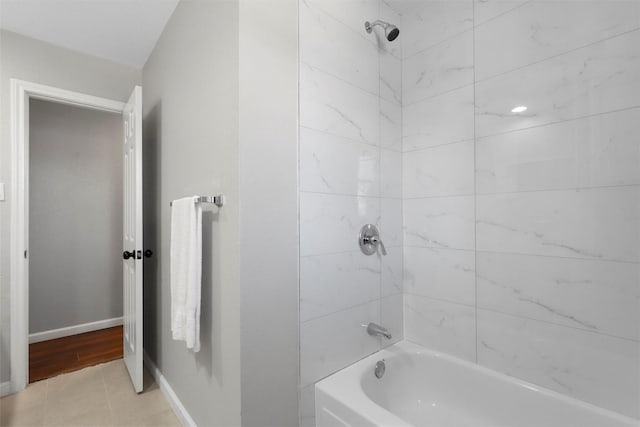 bathroom featuring tile patterned flooring, shower / bathing tub combination, and baseboards