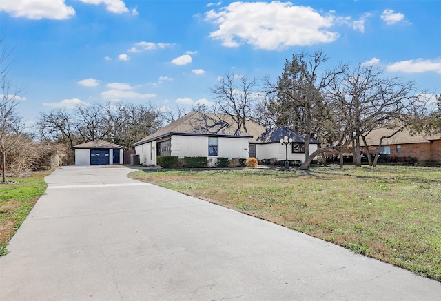 view of front facade featuring a garage, an outbuilding, and a front lawn