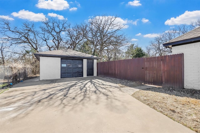 detached garage with fence and driveway