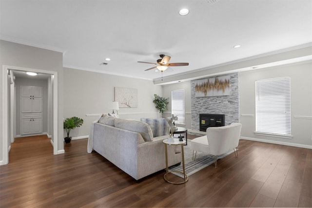 living room featuring dark wood-style floors, a fireplace, crown molding, and baseboards