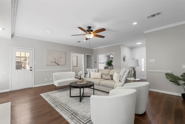 living area with wood finished floors, visible vents, and baseboards