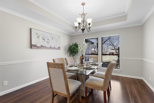 dining room with a raised ceiling, a notable chandelier, baseboards, and wood finished floors