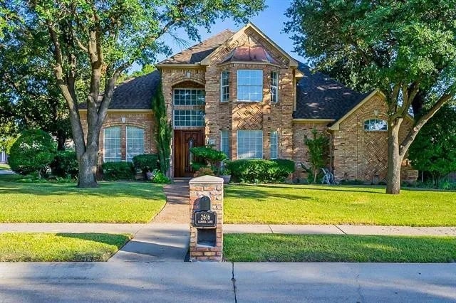 traditional home featuring brick siding and a front yard