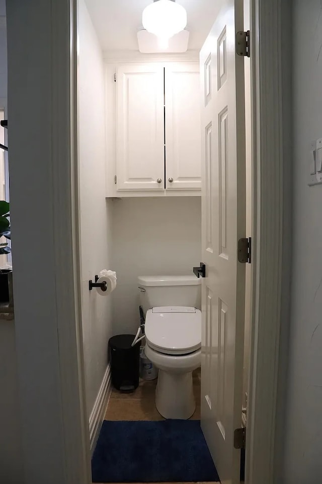 bathroom with toilet and baseboards