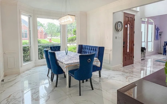 dining room featuring a healthy amount of sunlight, marble finish floor, ornamental molding, and a decorative wall