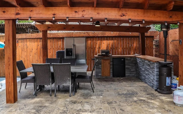 view of patio / terrace with a pergola, fence, outdoor dining area, and exterior kitchen